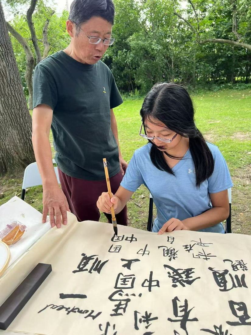 Calligrapher guiding a young visitor