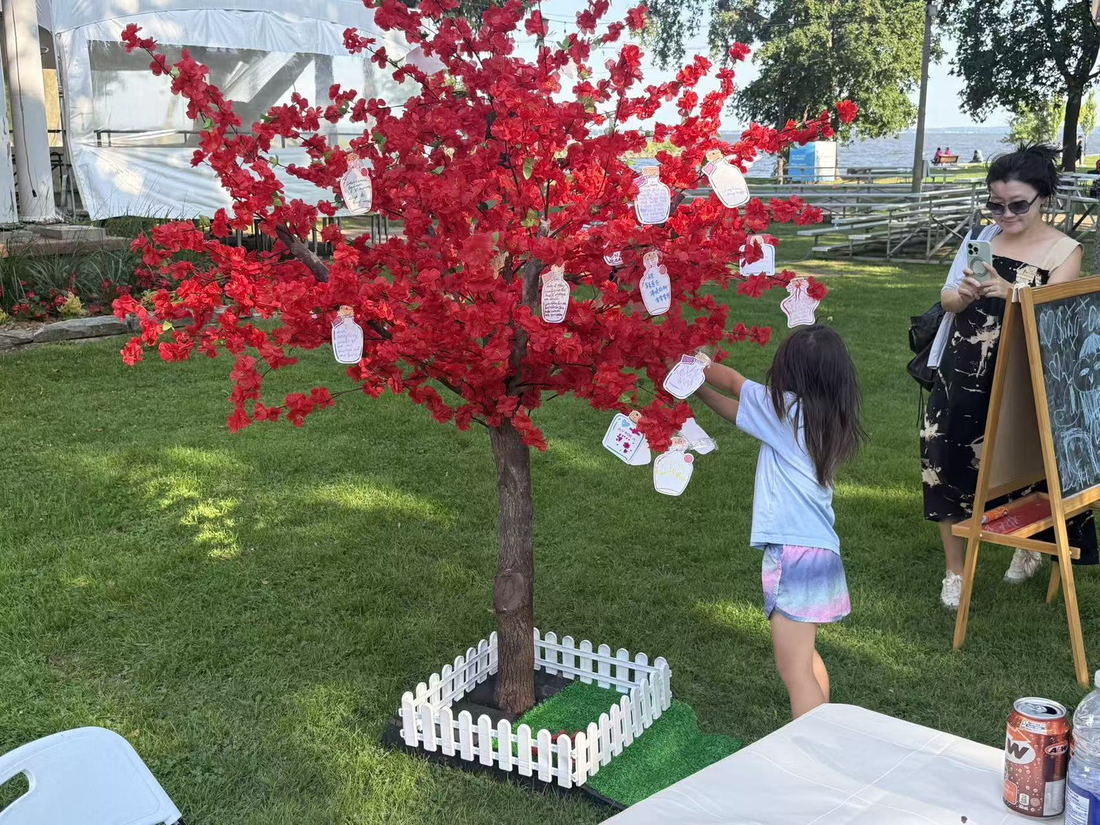 A child hanging a wish on the blossom tree